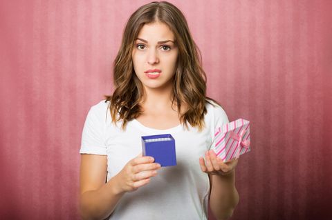 Top 10 Geschenke für Frauen: Eine Frau ist enttäuscht über ein Geschenk