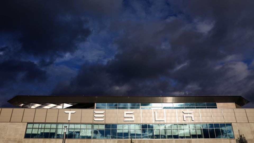 Der Tesla-Schriftzug auf der Fabrik in Grünheide unter bewölktem Himmel
