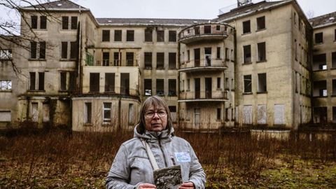 Beatrix Höttger-Schiffers hält auf dem Gelände der ehemaligen Klinik Aprath ein historisches Bild in der Hand