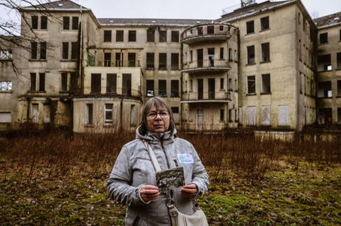Beatrix Höttger-Schiffers hält auf dem Gelände der ehemaligen Klinik Aprath ein historisches Bild in der Hand