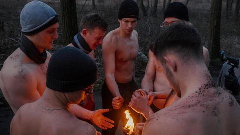 Männer stehen um eine Fackel