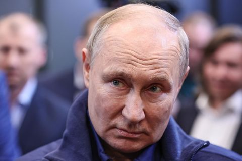 Wladimir Putin schaut mit gesenktem Kopf schräg nach oben.