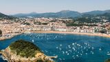 Familien besuchen besonders gerne den Badestrand im spanischen Küstenort San Sebastian. Der La Concha bietet viel Platz zum Entspannen und Surfen und dabei eine zauberhafte Kulisse aus Meer und grün bewachsenen Hügeln.