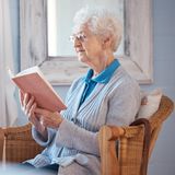 Foto einer Seniorin im Sessel, lesend