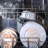 Foto einer geöffneten Spülmaschine mit schmutzigem Geschirr