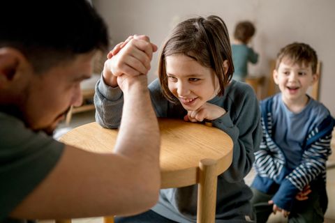 Resilienz: Vater und Tochter machen Armdrücken