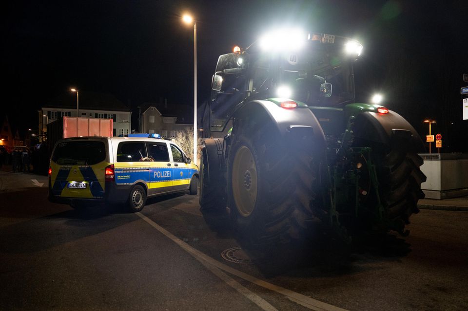 Ein Polizei Wagen steht beim Bauern Protest in Biberach neben einem Traktor