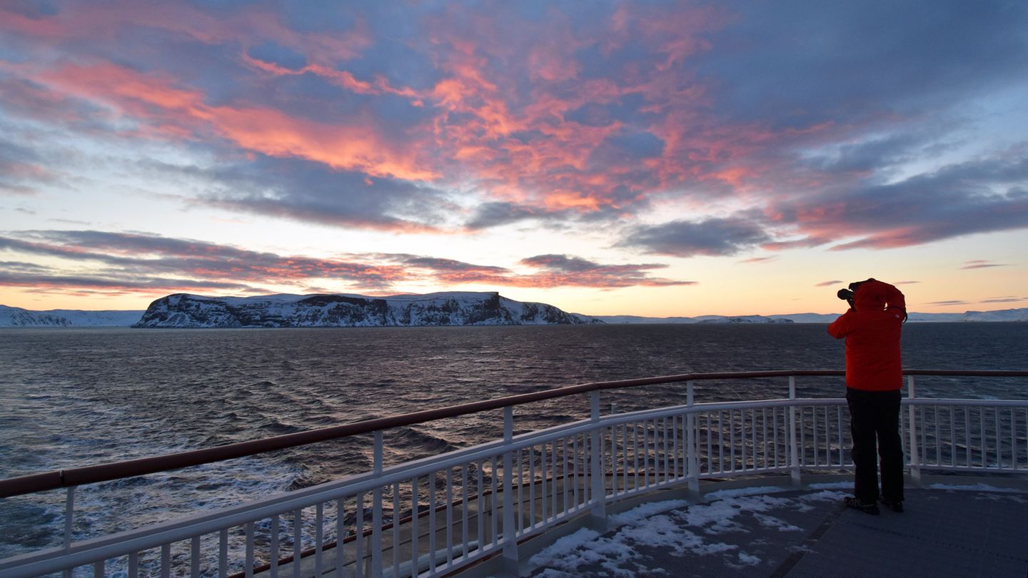 Am nächsten Morgen bietet der Himmel im Osten ein weiteres Spektakel, als hinter Honningsvåg die Sonne aufgeht. Der Ort liegt auf Magerøya, der Insel mit dem Nordkap.