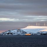 Von Süden kommend steuert ein Schiff von Hurtigruten den Hafen von Havøysund an. Der kleine Ort bezieht seine elektrische Energie aus dem nördlichsten Windpark Europas.