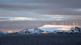 Von Süden kommend steuert ein Schiff von Hurtigruten den Hafen von Havøysund an. Der kleine Ort bezieht seine elektrische Energie aus dem nördlichsten Windpark Europas.