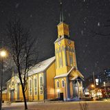 Der mitternächtliche Aufenthalt in Tromsø reicht für einen Stadtrundgang im Schneetreiben – im Bild der aus Holz errichtete Dom. Mit der Lage 400 Kilometer über dem nördlichen Polarkreises war die Stadt früher der Ausgangspunkt von Arktisexpeditionen der Polarforscher Fridtjof Nansen und Roald Amundsen.