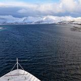 Am Morgen des dritten Tages wird der Risøy-Kanal befahren. Die einst seichte Meerenge bei der Insel Andøya konnten Menschen vor gut hundert Jahren noch bei Ebbe durchwaten, bevor die heute nur 100 Meter breite 7 Meter tiefe Fahrrinne ausgebaggert wurde. Im Hintergrund ragen die mit Neuschnee bedeckten Berge der Vesterålen auf.