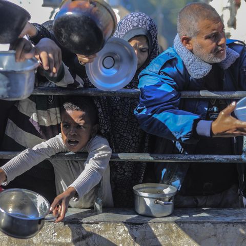 In Gaza warten Menschen mit leeren Töpfen in den Händen auf die Verteilung einer Hilfslieferung