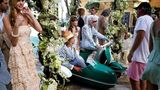 Iris Apfel sitzt auf einer Vespa mit Beiwagen, umringt von Menschen während eines Shootings