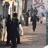 Schwerbewaffnete Polizisten stehen vor einem Gewerbegrundstück im Bezirk Friedrichshain und fahnden dort nach den früheren RAF-Terrorgruppenmitgliedern Ernst-Volker Staub und Burkhard Garweg