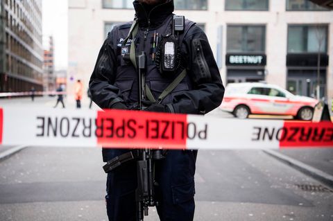 Ein Polizist steht vor einem Absperrband in Zürich