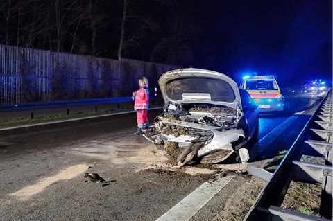 Ein Autp steht im Dunkeln beschädigt und voller Mist auf einer Bundesstraße in Brandenburg