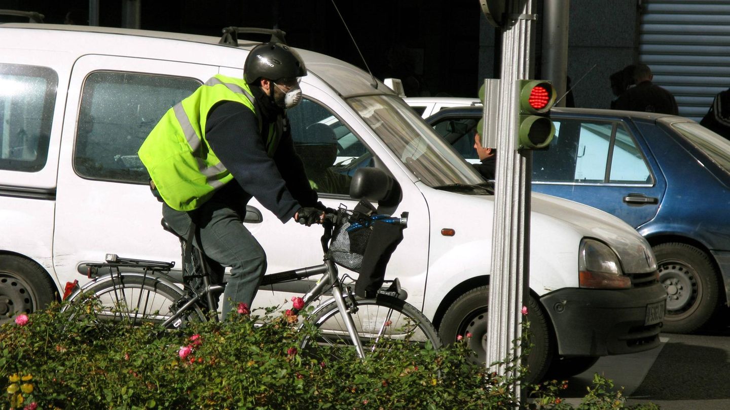 Ein Mann mit Fahrrad an einer roten Ampel in Madrid