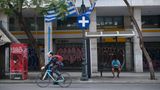 Ein Mann fährt auf einem Fahrrad über eine Straße in Athen