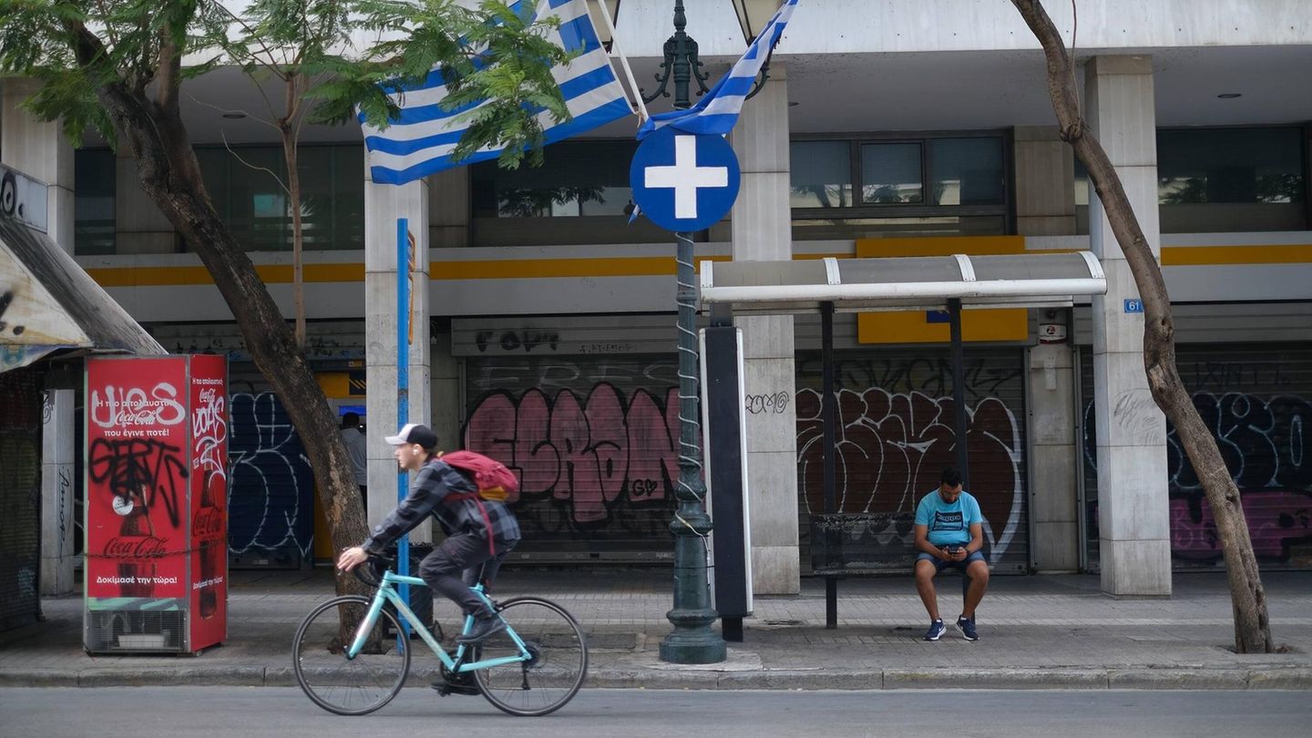Athen: Rote Ampel ignorieren kann mit 700 Euro Bußgeld bestraft werden Ein Mann fährt auf einem Fahrrad über eine Straße in Athen