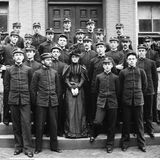 Eine Frau als "Maskottchen" zwischen Absolventen