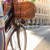 Ein Fahrrad mit Fahrradkorb vor dem Kolosseum in Rom