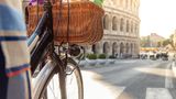 Ein Fahrrad mit Fahrradkorb vor dem Kolosseum in Rom