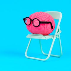 Symboloto für Allgemeinwissen-Quiz: Illustriertes pinkes Gehirn mit schwarzer Brille sitzt auf einem Klappstuhl