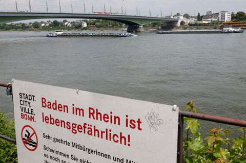 Mit einem Hinweisschild warnt die Stadt Bonn die Menschen vor den Gefahren beim Schwimmen im Rhein