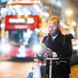 Ein Mann in London steht mit einem Fahrrad auf einer abendlichen Straße