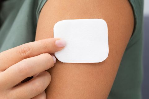Hormonersatztherapie: Eine Frau klebt sich ein Pflaster auf den Oberarm