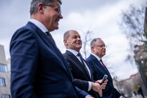 Hessens Ministerpräsident Boris Rhein begrüßt Kanzler Scholz und seinen niedersächsischen Amtskollegen Stephan Weil (rechts). Rhein leitet die Konferenz zur Migration