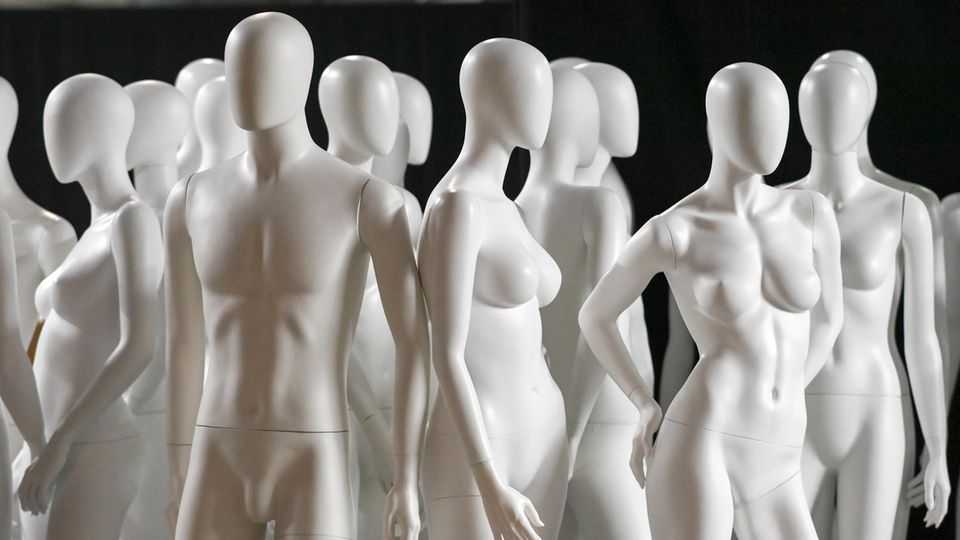 Weiße Schaufensterpuppen stehen ohne Kleidung am Rande der Berliner Modewoche in einer Halle