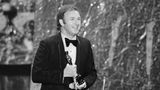 Gene Hackman lächelt au der Bühne, als er den Oscar hält.