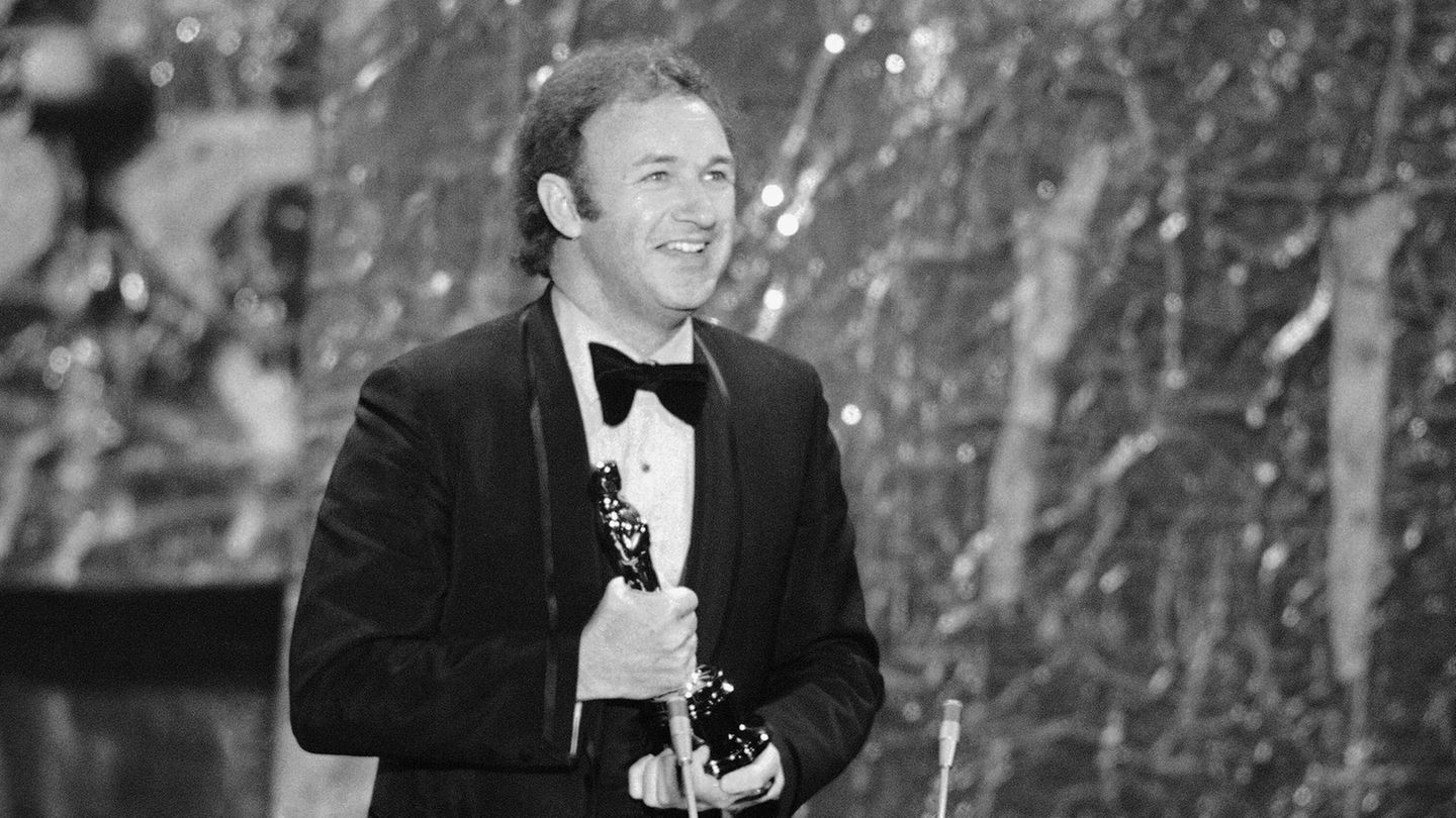 Gene Hackman lächelt au der Bühne, als er den Oscar hält.