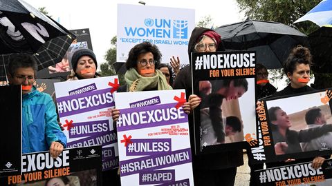 Frauen mit zugeklebten Mündern halten Transparente hoch, um sich mit den Opfern sexualisierter Gewalt zu solidarisieren