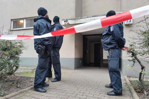 Drei Beamte hinter der Absperrung vor der Wohnung von Daniela Klette, wo Waffen gefunden wurden