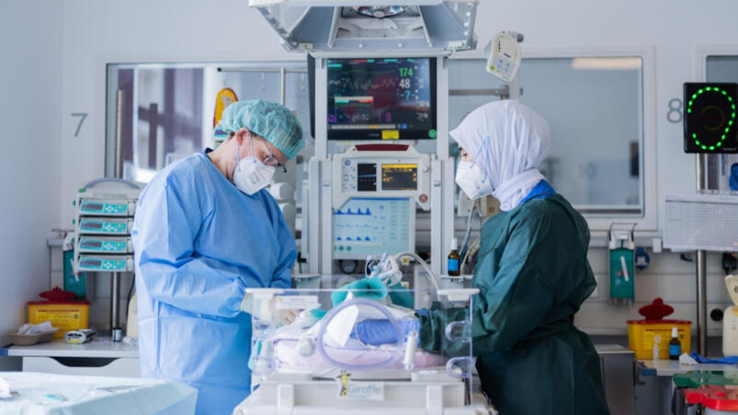 Oberarzt untersucht ein Neugeborenes in einer Kinderklinik
