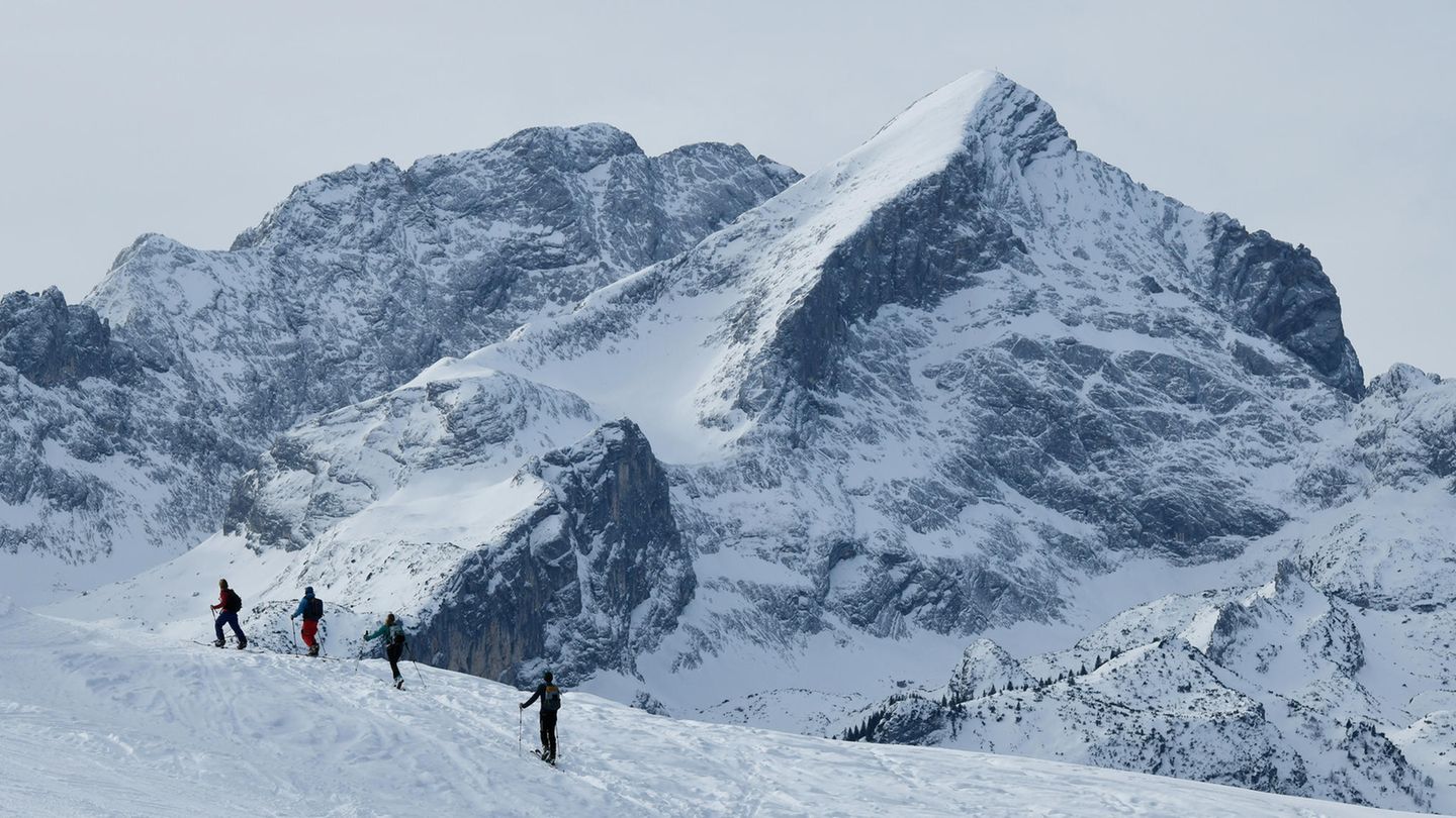 Schweiz: Vier Menschen auf Skiern sind auf einer Skitour in den Alpen unterwegs