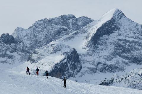 Schweiz: Vier Menschen auf Skiern sind auf einer Skitour in den Alpen unterwegs