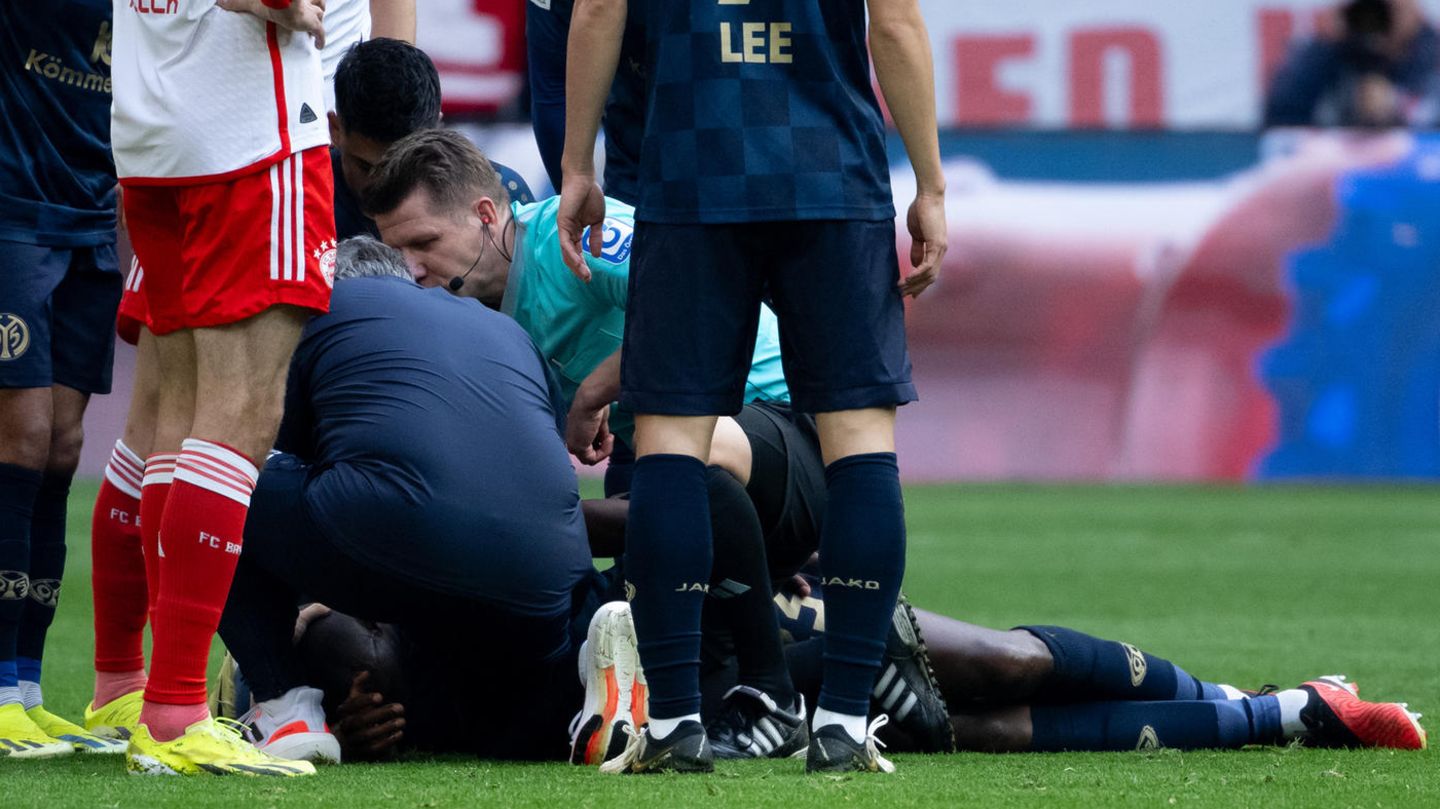 Schiedsrichter Patrick Ittrich beugt sich über den kollabierten Josuha Guilavogui