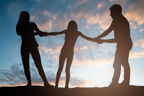 Silhouette von zwei Erwachsenen, die an einem Kind zerren