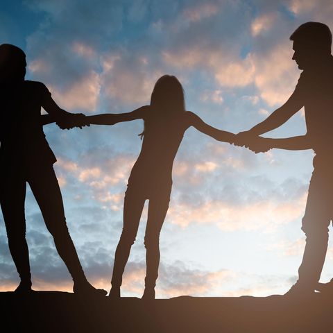 Silhouette von zwei Erwachsenen, die an einem Kind zerren