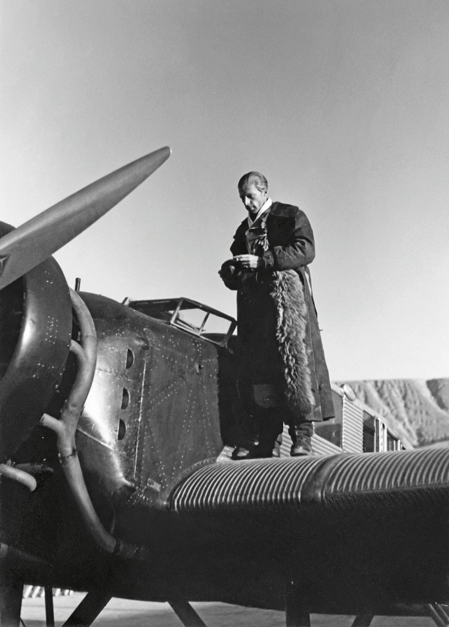 Graf zu Castell mit fellbesetztem Pilotenmantel auf der Tragfläche einer Junkers W 34