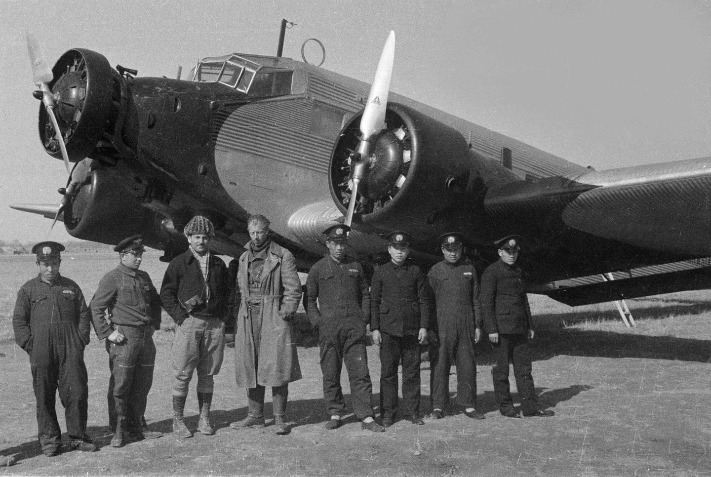 Graf zu Castell (Mitte, im Mantel) und seine Besatzung vor einer Ju 52. Links neben ihm steht der amerikanische Fotograf und Journalist Harrison Forman, der ihn im Februar 1936 auf einem Flug von Shanghai nach Lanzhou begleitet hat.