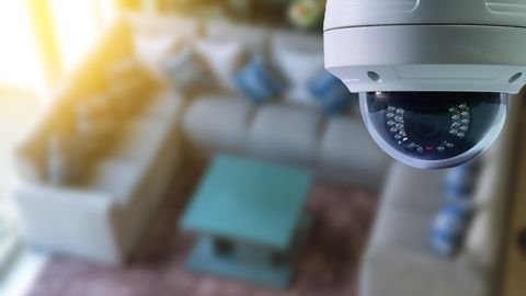 Symbolfoto für Text über Airbnb: Eine Überwachungskamera hängt in einem Wohnzimmer