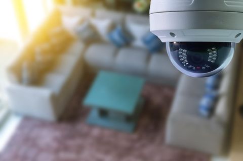 Symbolfoto für Text über Airbnb: Eine Überwachungskamera hängt in einem Wohnzimmer