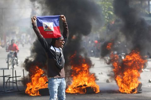Ein Demonstrant hält eine haitianische Flagge während Protesten für den Rücktritt von Premierminister Henry hoch