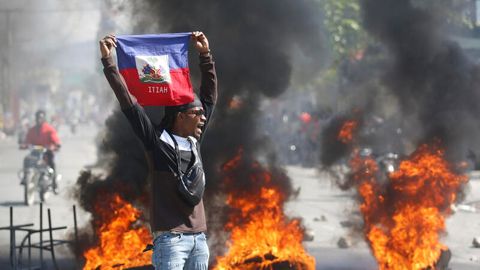 Ein Demonstrant hält eine haitianische Flagge während Protesten für den Rücktritt von Premierminister Henry hoch