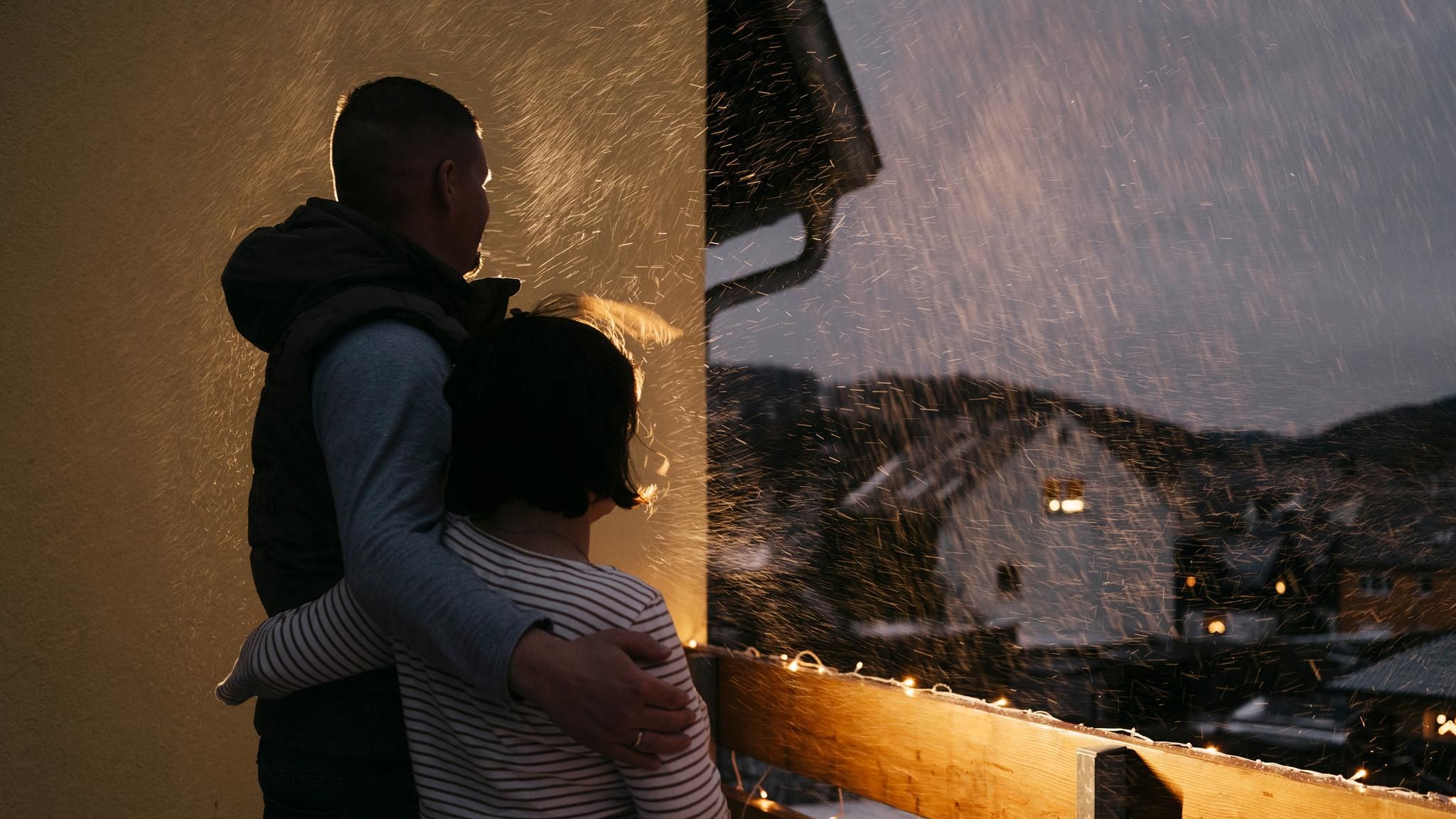 Zwei Personen von hinten Arm in Arm auf einem Balkon